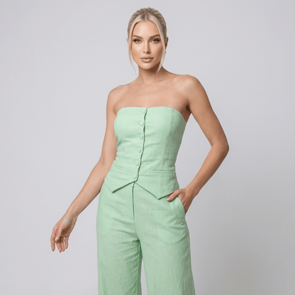 Conjunto Feminino Calça Pantalona com Blusa Tomara que Caia – Elegância e Versatilidade para Todas as Ocasiões | Fernanza. Look em tom verde bebê, com blusa tomara que caia estruturada, fechamento frontal com botões forrados e caimento ajustado tipo corset. A calça pantalona de cintura alta traz leveza e sofisticação, perfeita para eventos diurnos, ambientes de trabalho elegantes ou encontros especiais com toque de frescor e estilo.